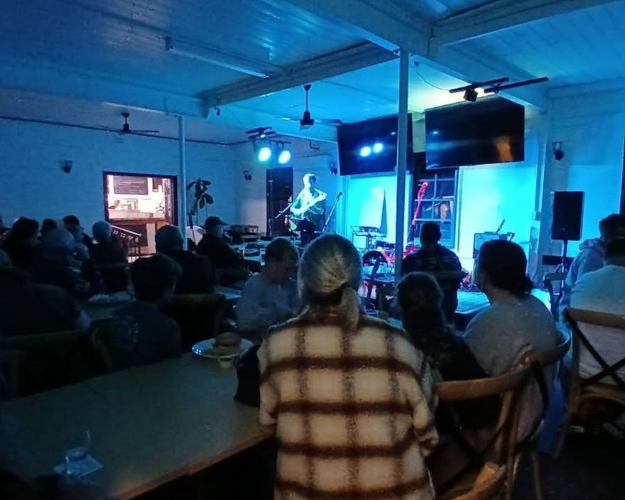 Photo of crowd watching a performer at open mic