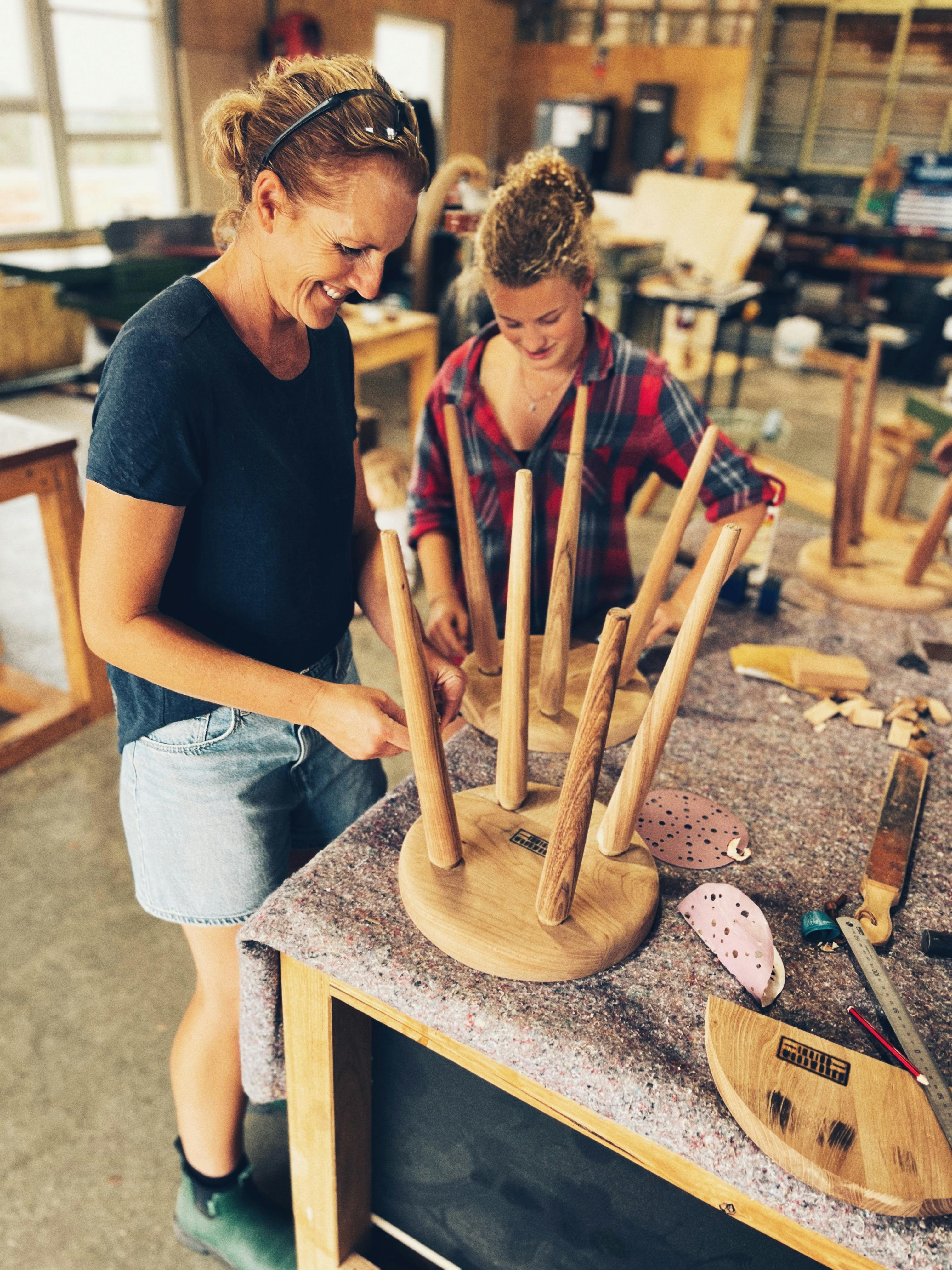 Two people assembling their four legged stools