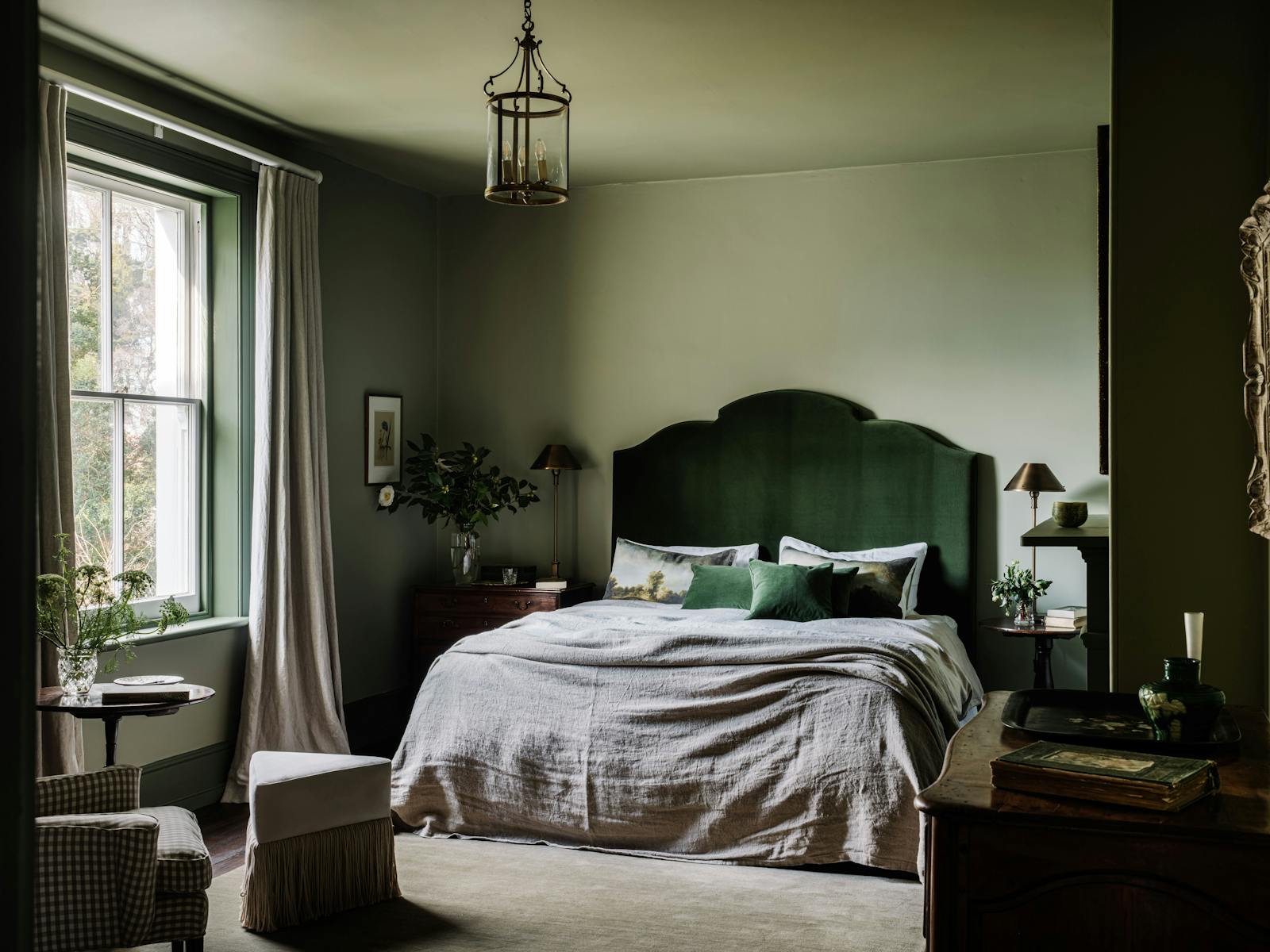 A Georgian bedroom styled with luxury linen, shades of green with a large window.