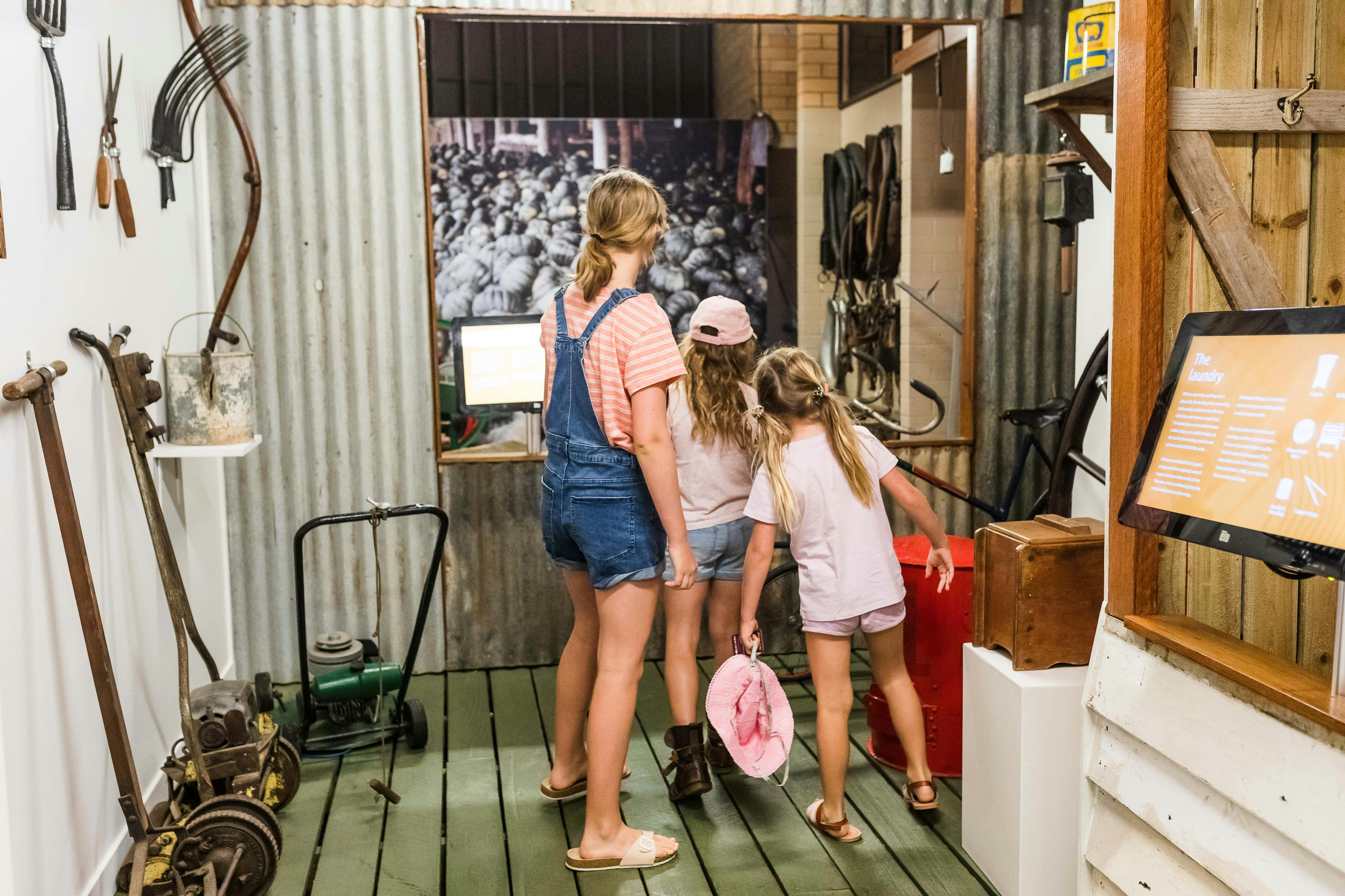 Three kids exploring a shed display