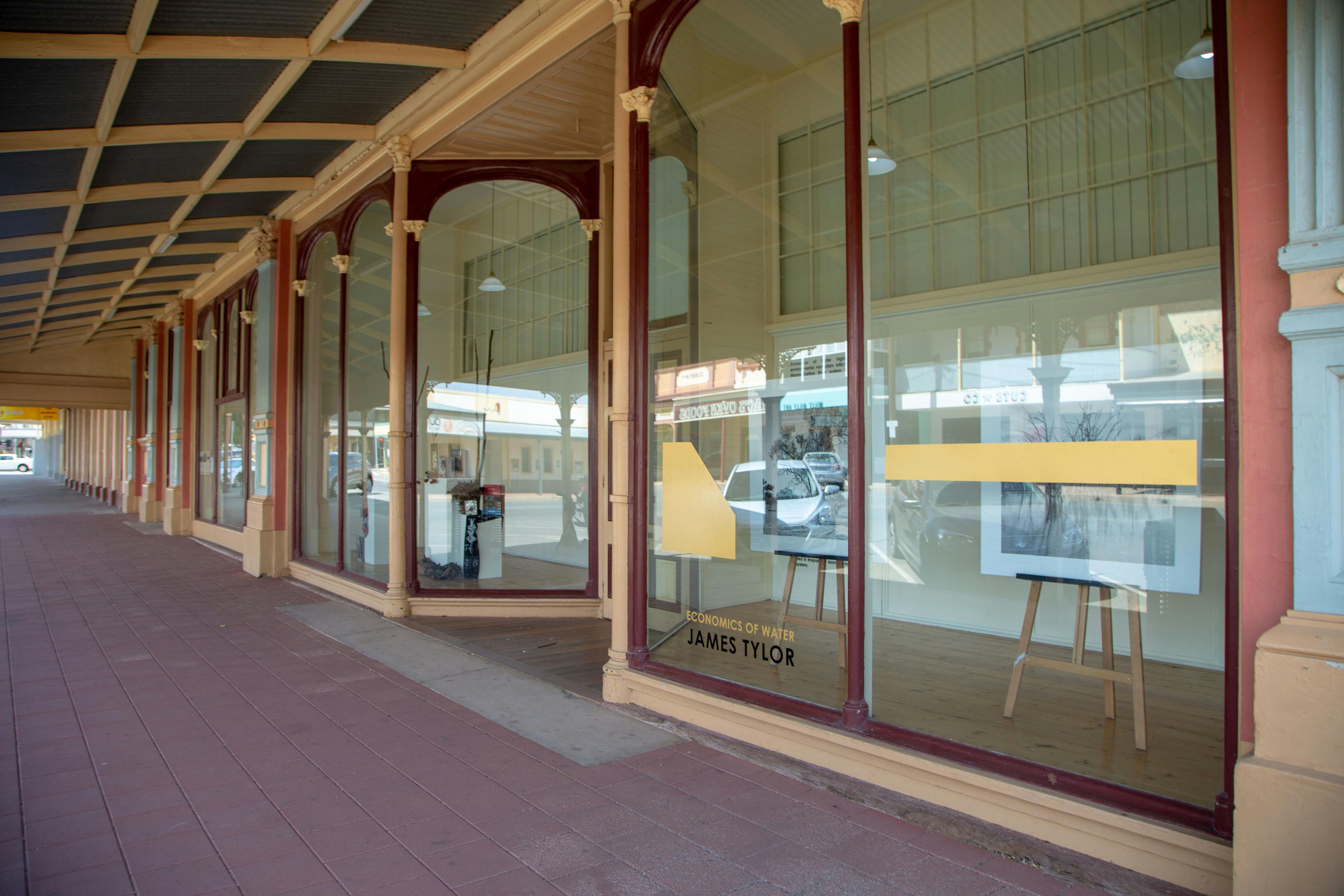 Image of outside artgallery showing sidewalk and glass windows