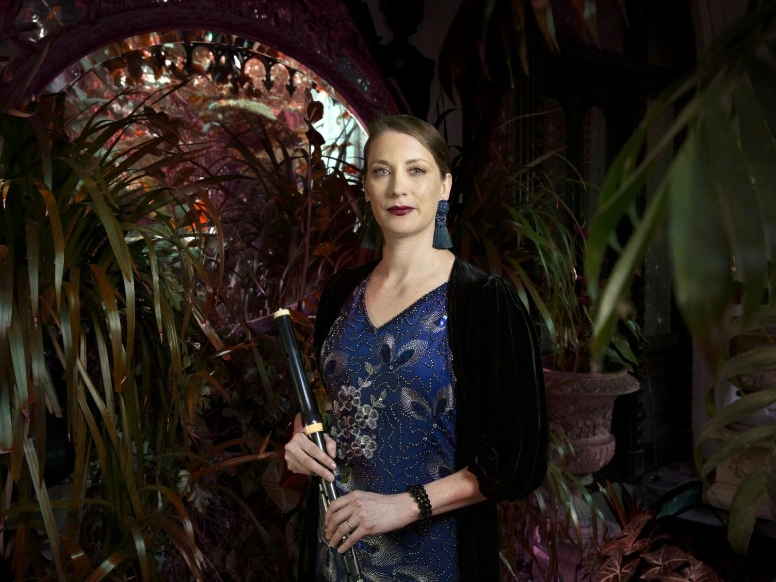 A flute player in am elegant blue dress