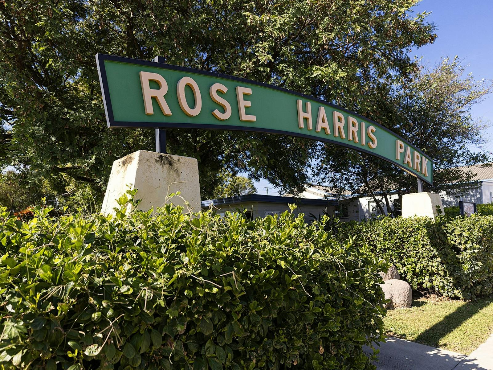 Green entrance sign to Rose Hill Park, with gardens around and footpaths. Green entrance sign to Rose Hill Park, with gardens around and footpaths.