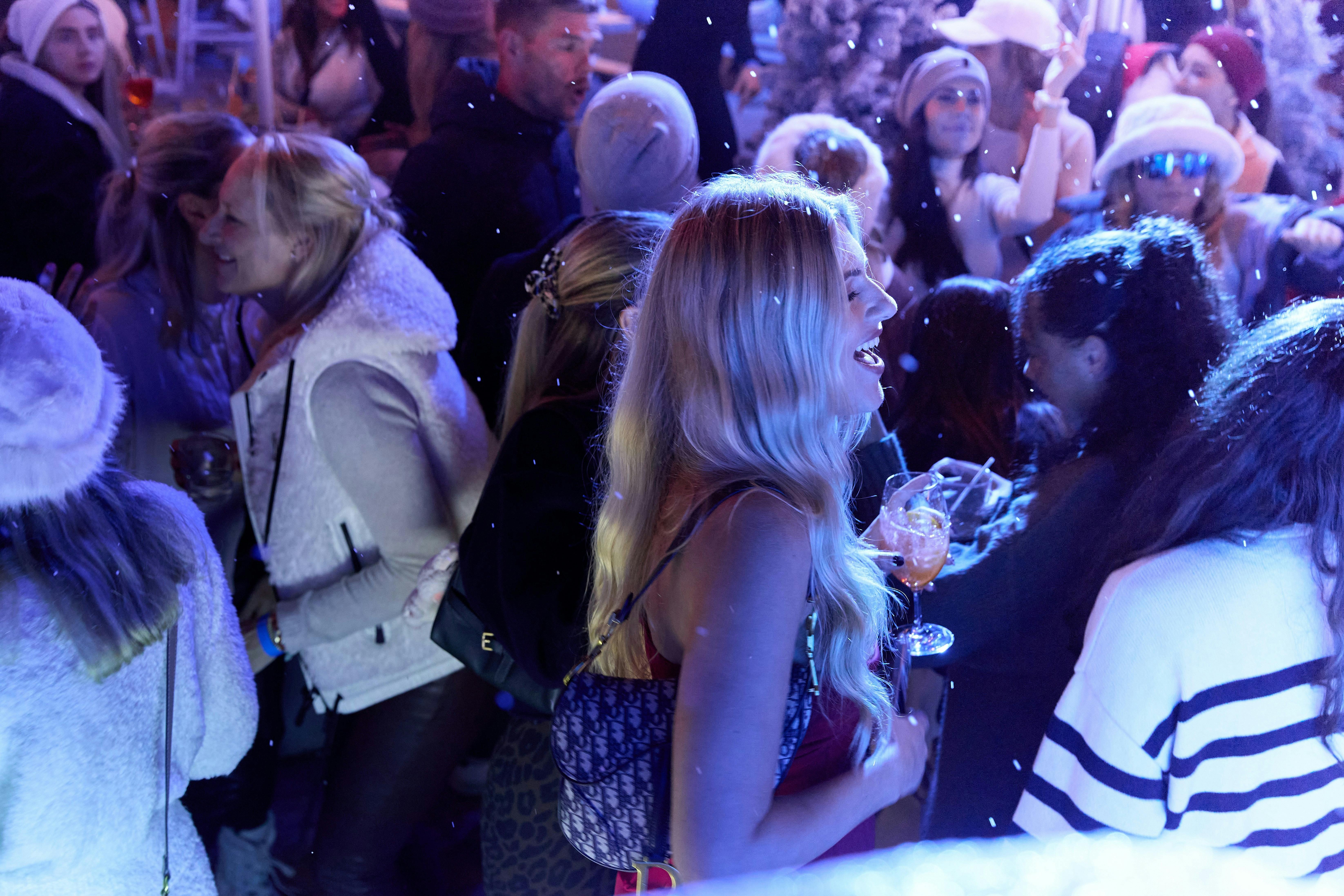 Women holds drink at apres ski party