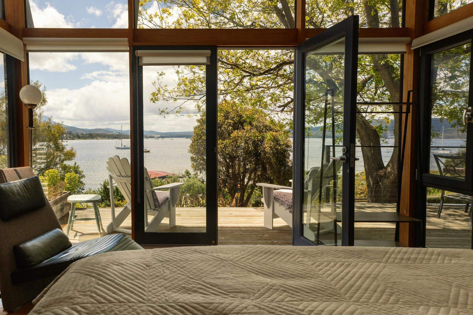 View of deck, garden and Snug Bay from bed in master bedroom at Snug on the Bay