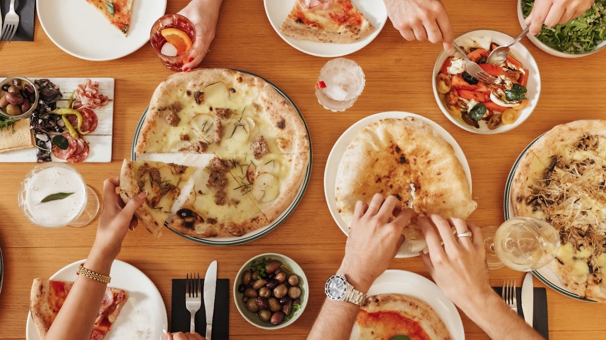 4 people sharing Fire Baby Pizza on the table