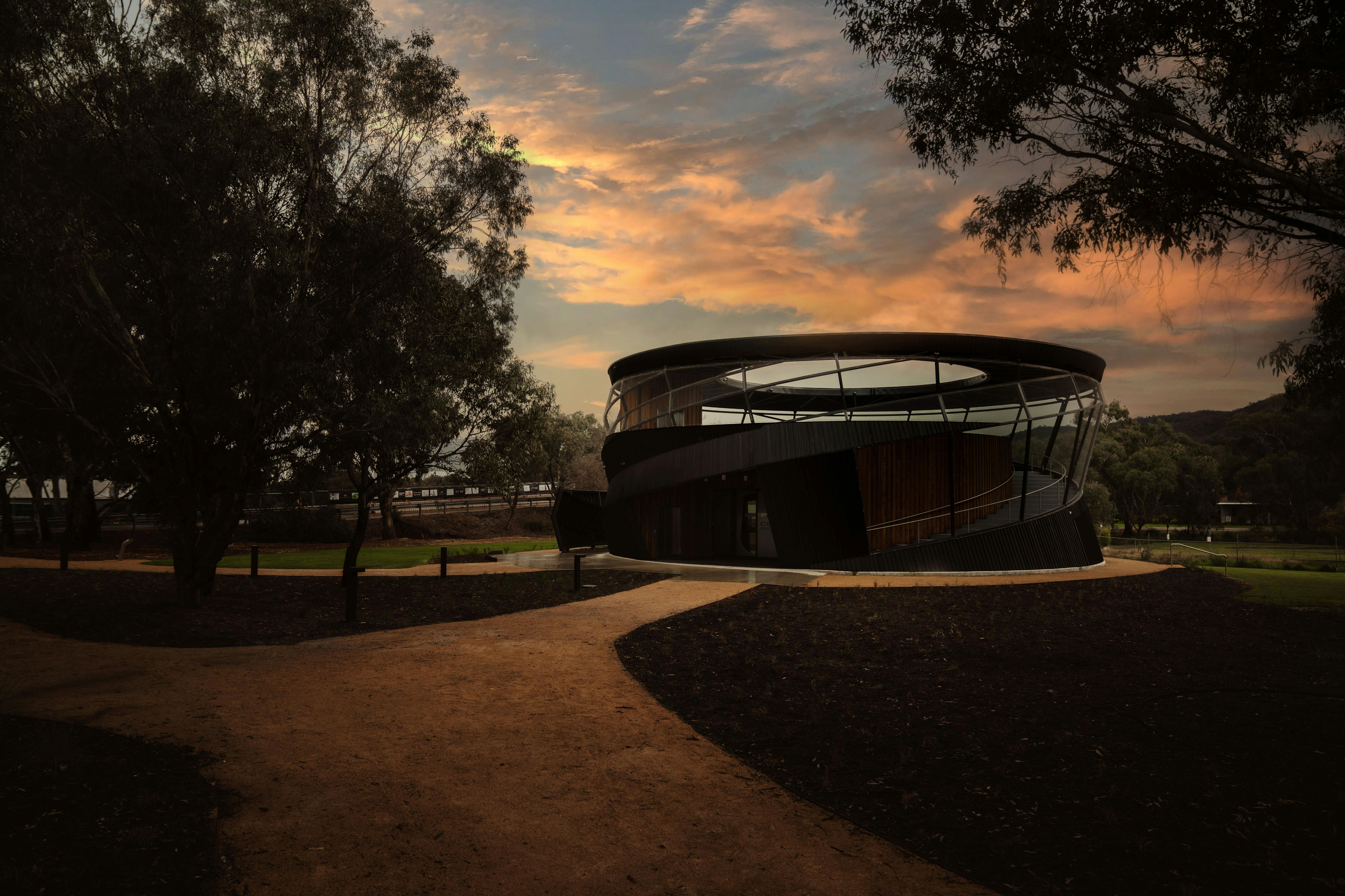 Dark sunset with round building with open roof in the foreground