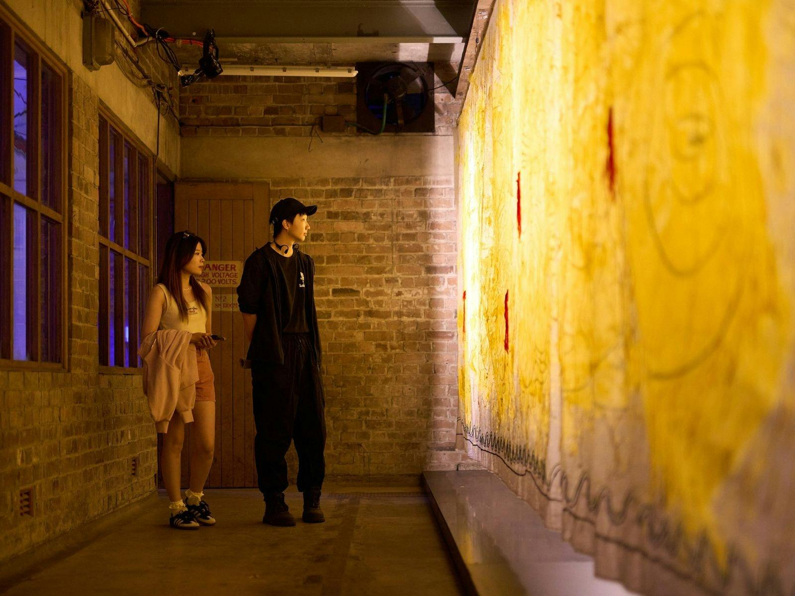 A couple looks at a glowing artwork