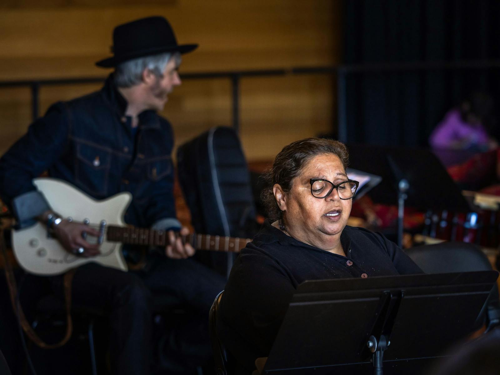 A man plays guitar while a woman sings