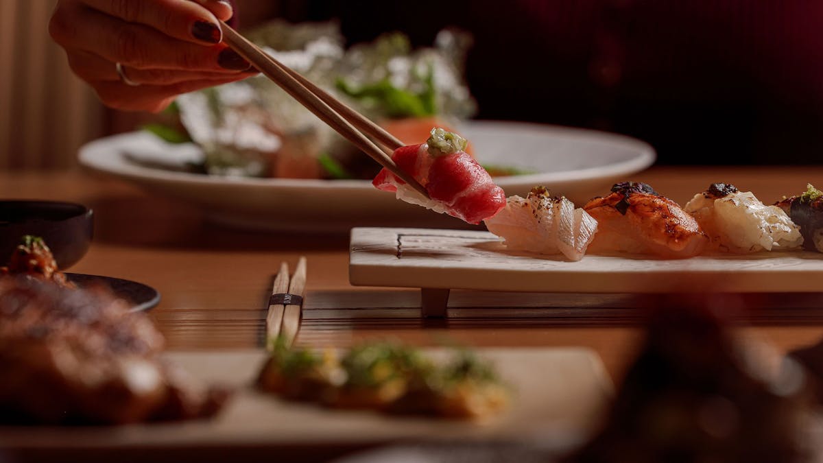 chopsticks picking up a piece of sushi