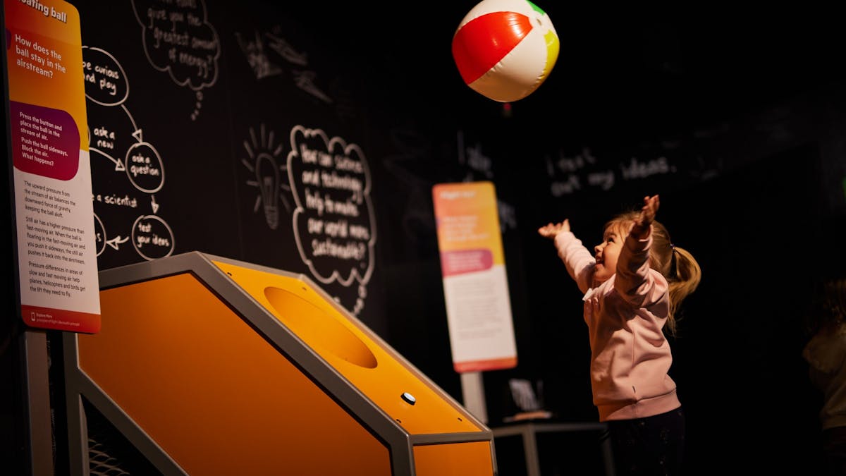 Child trying to catch a beach ball in mid air