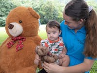 Image of Nannies On A Mission holding a baby at a Teddy Bear's Picnic