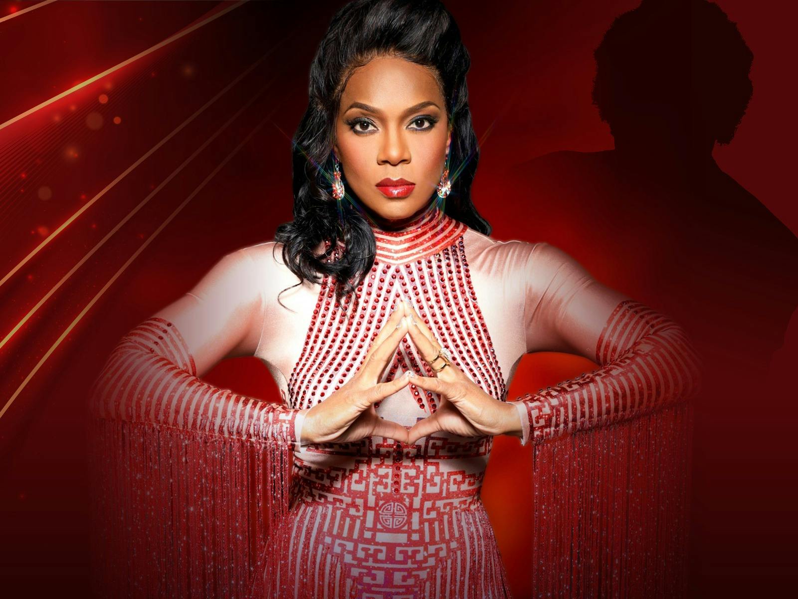 A woman standing with her hands together in front of a red background and shadow