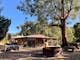 Large outdoor fire pit and seating with The Stables accommodation in background