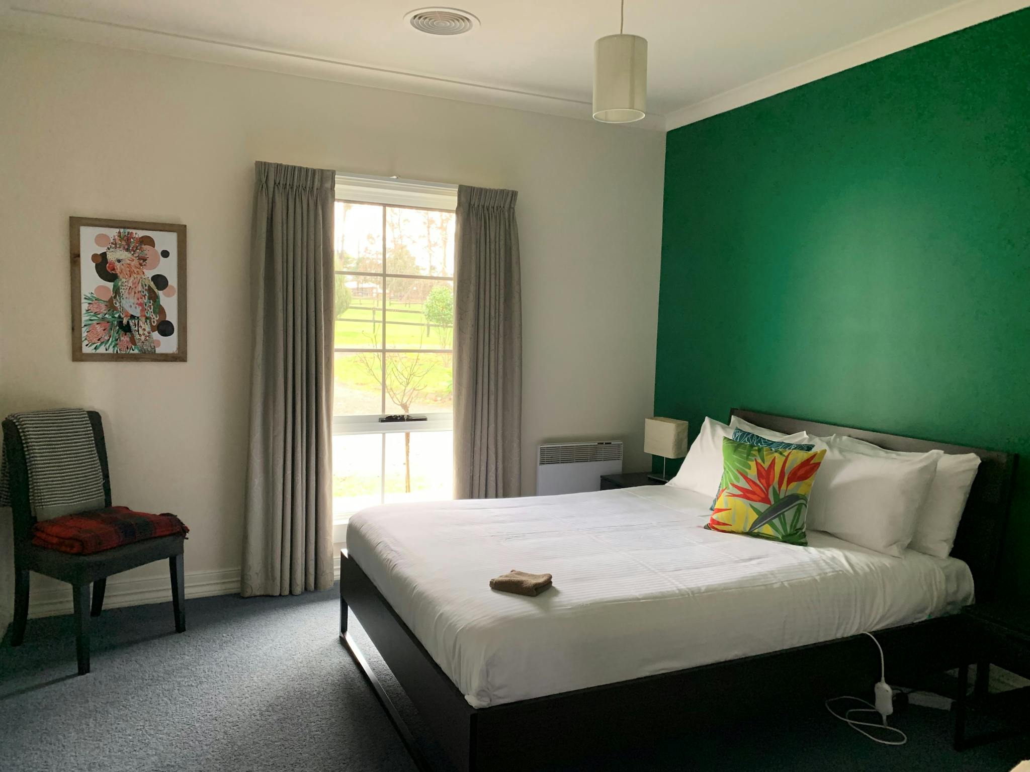 A queen bed and a single bed in a room with a green wall