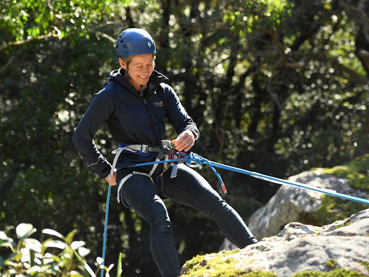 Smiling woman abseiling