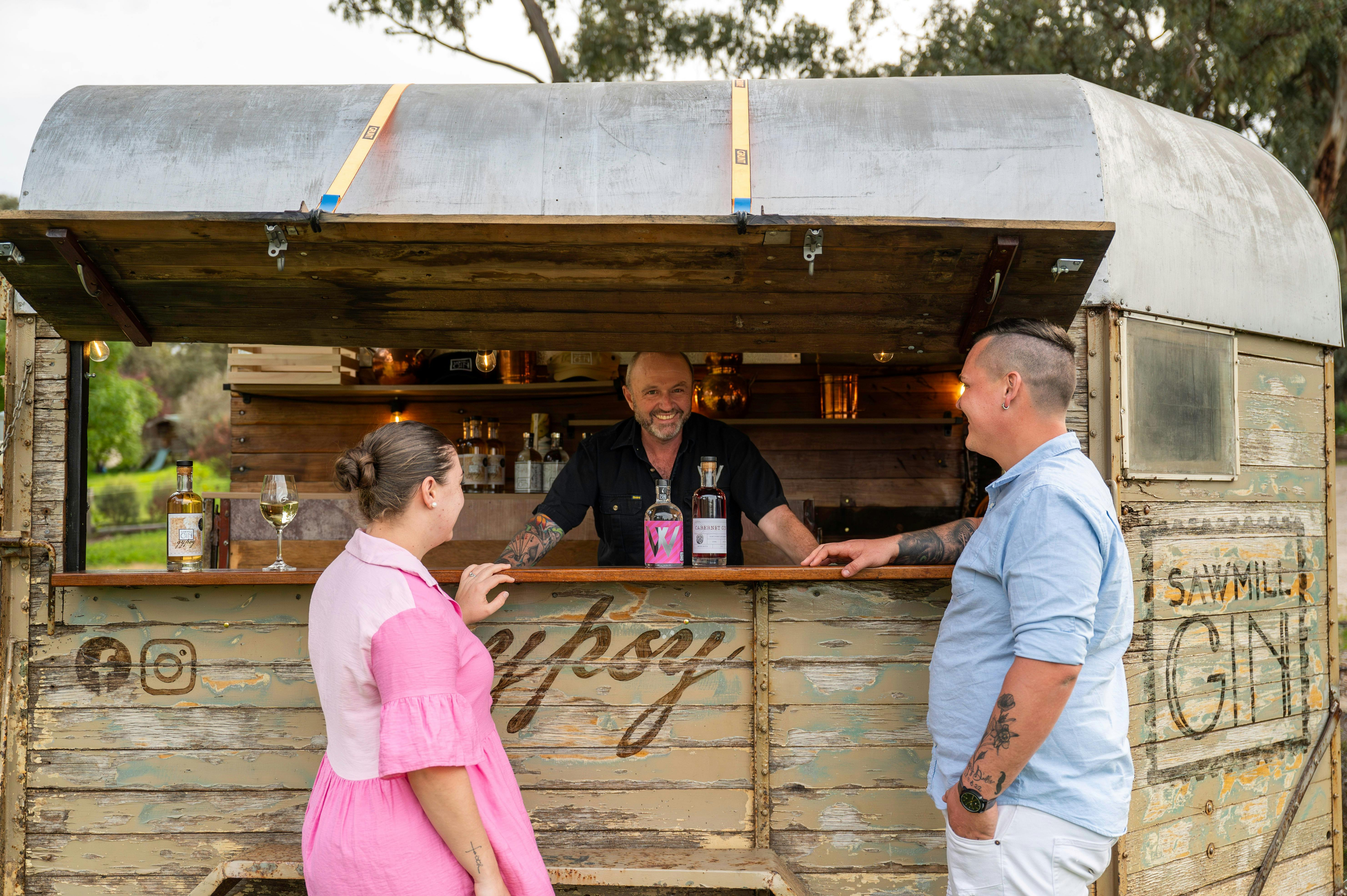 Heritage horse float bar with a couple and the bartender smiling