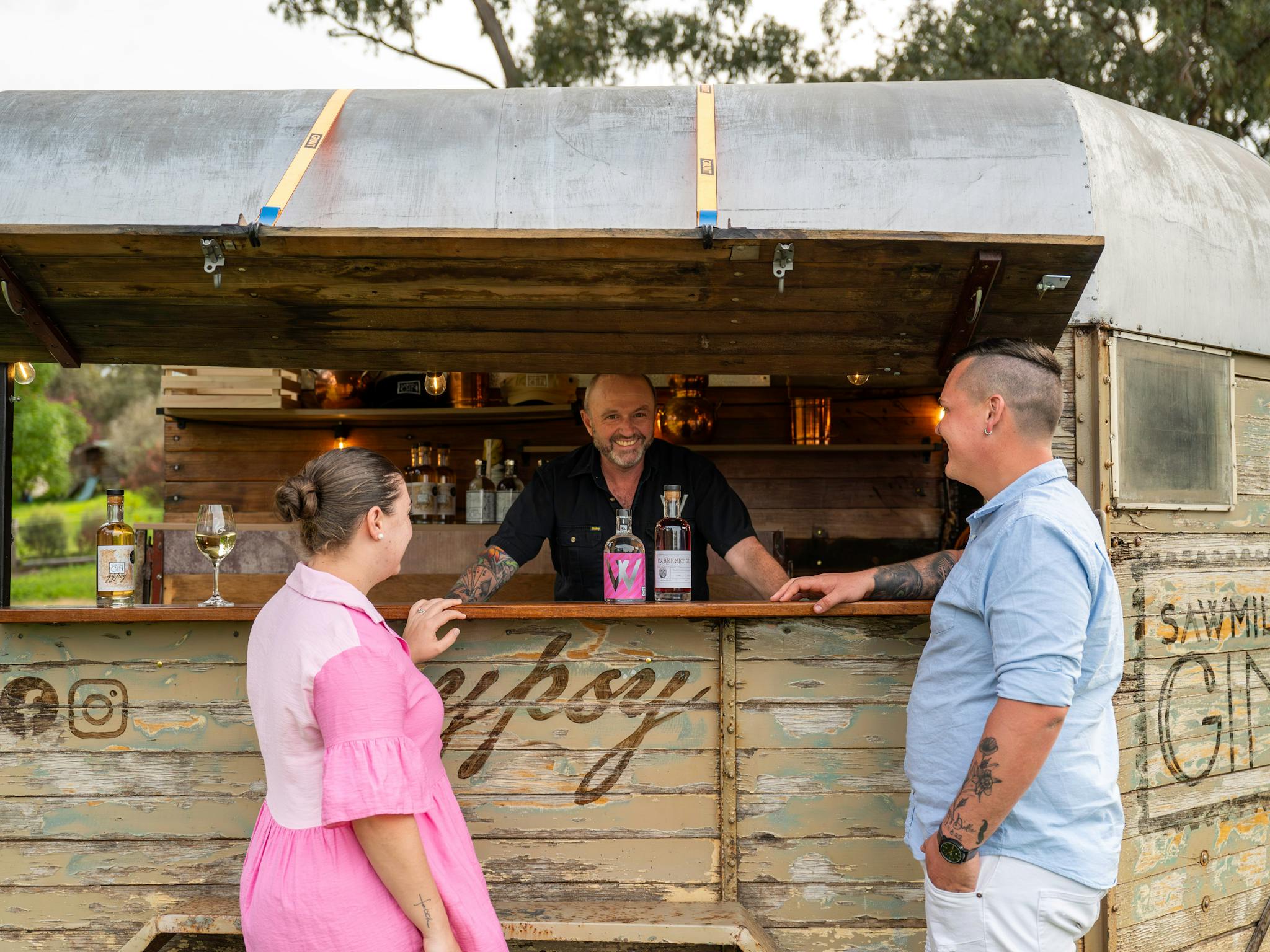 Heritage horse float bar with a couple and the bartender smiling
