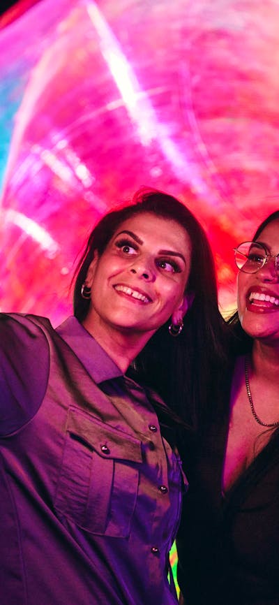 Two females capturing a selfie in front of an Enlighten installation