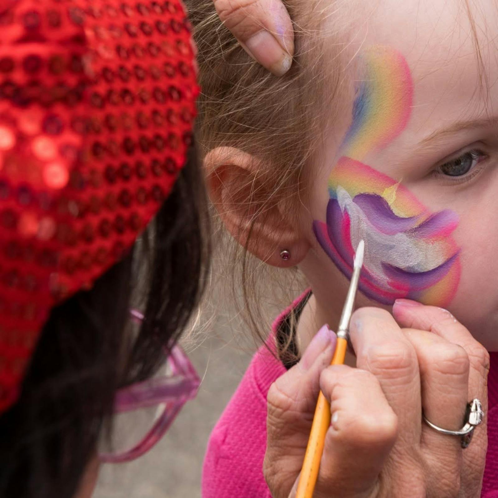 A child enjoying her face being painted