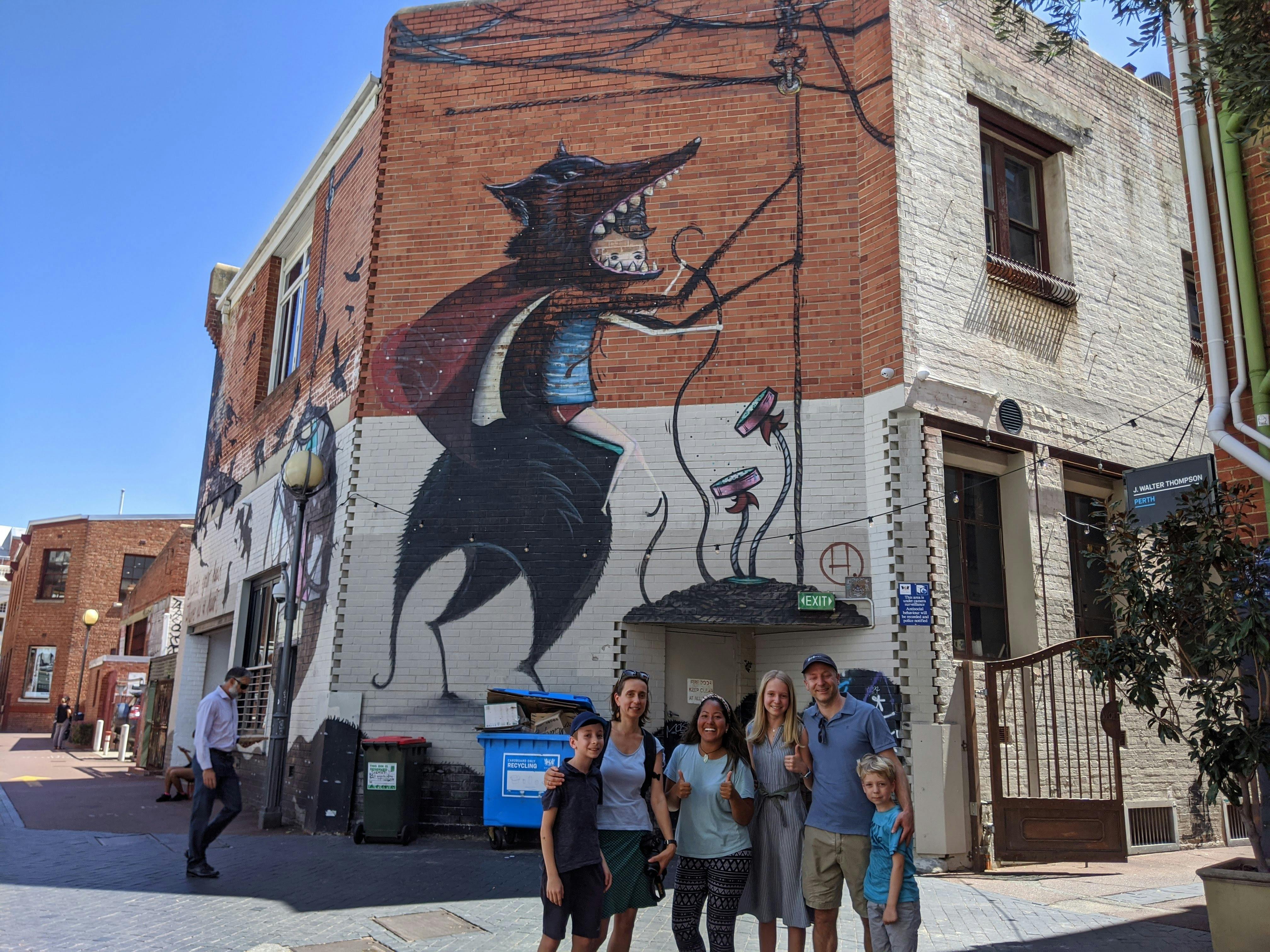 a family posing in front of a large wall mural