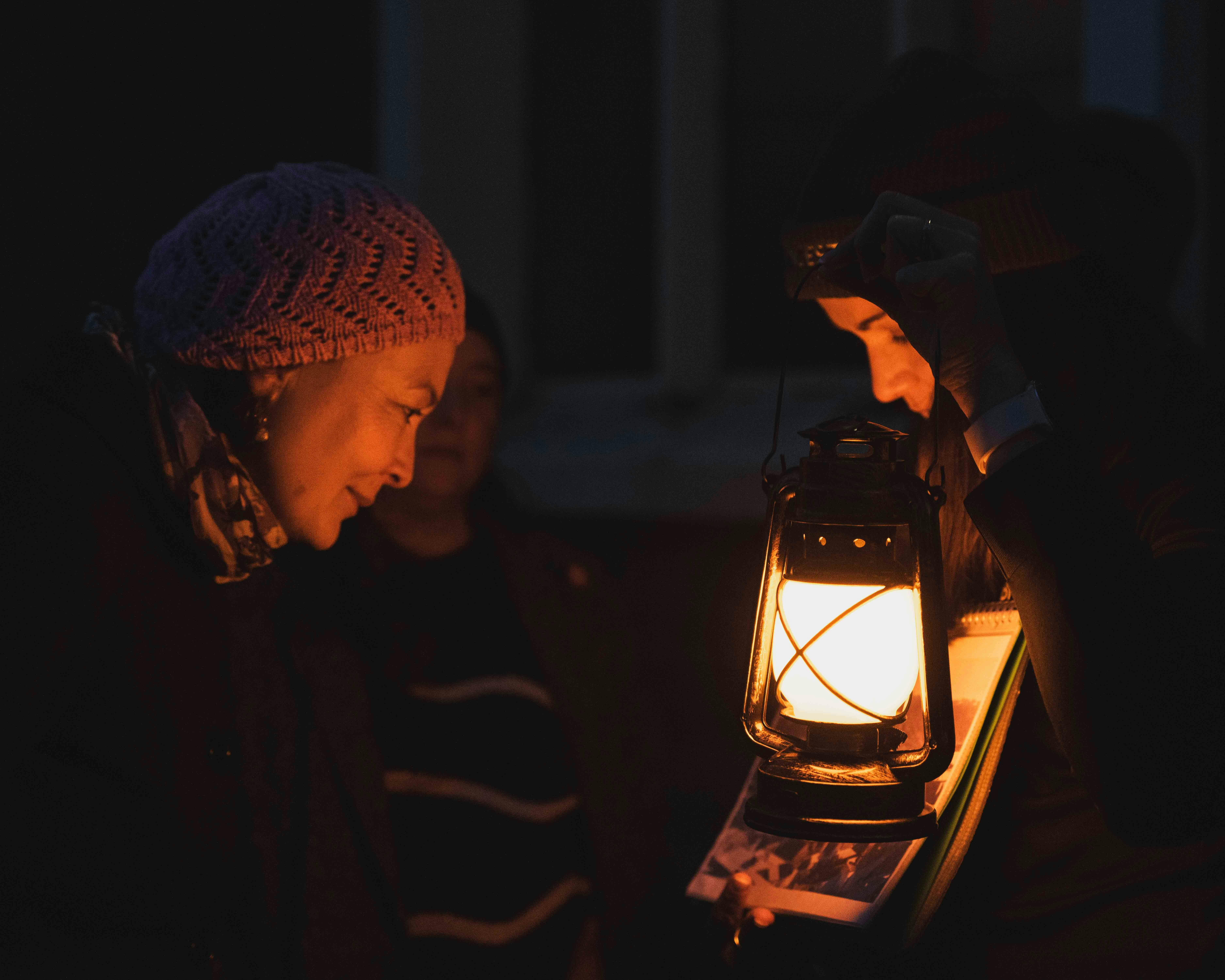 Guest and guide illuminated by a lantern during the Dark Side of Launceston evening walking tour.