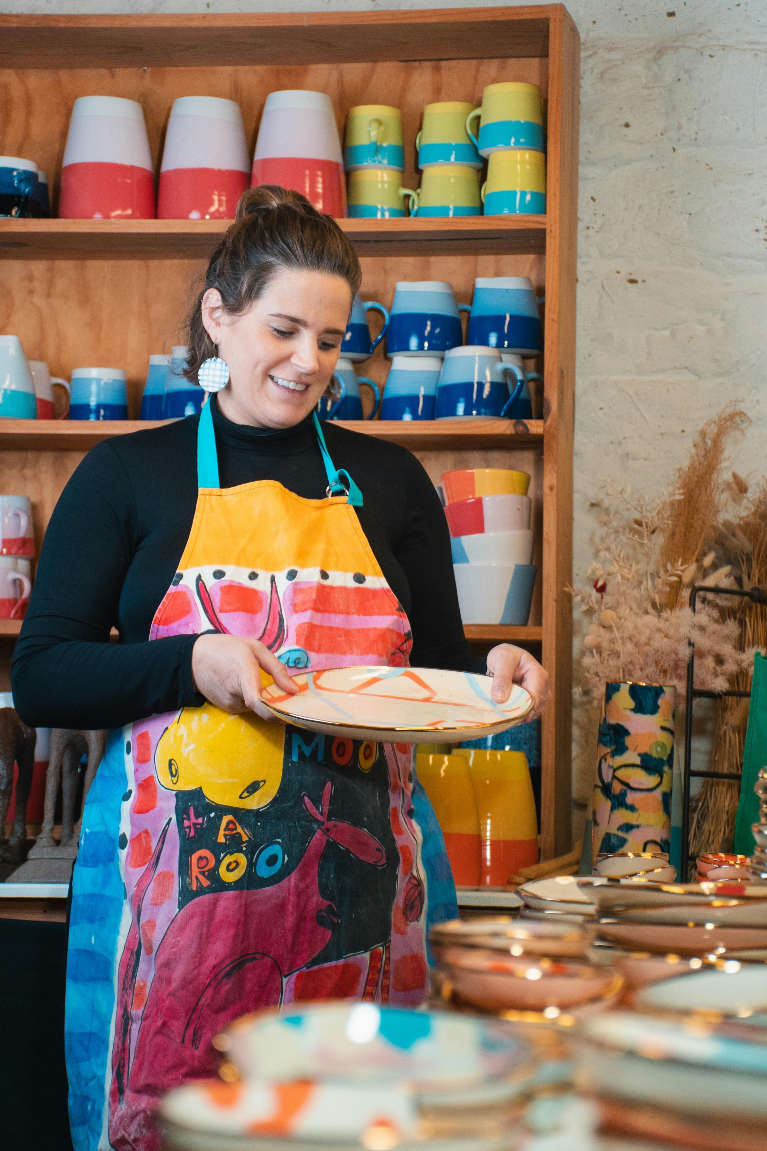 Ruby holding a plate in her studio
