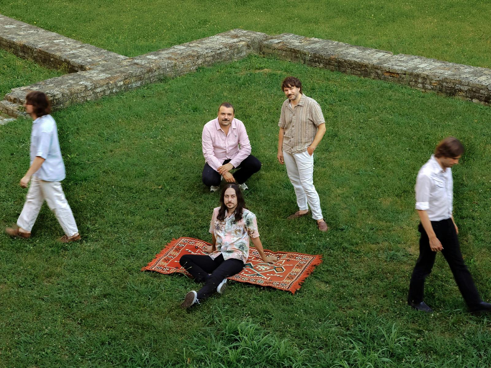 A group of people standing and sitting on grass