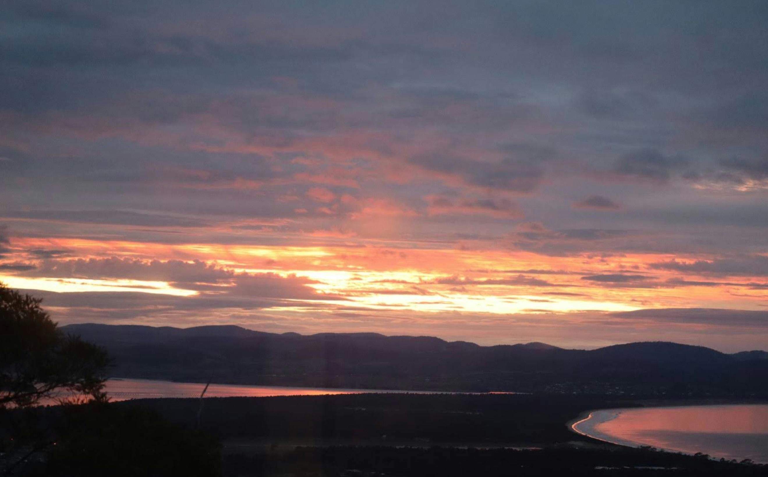 Sunset over the Tasmanian landscape viewed from Devil House at Mt Rumney