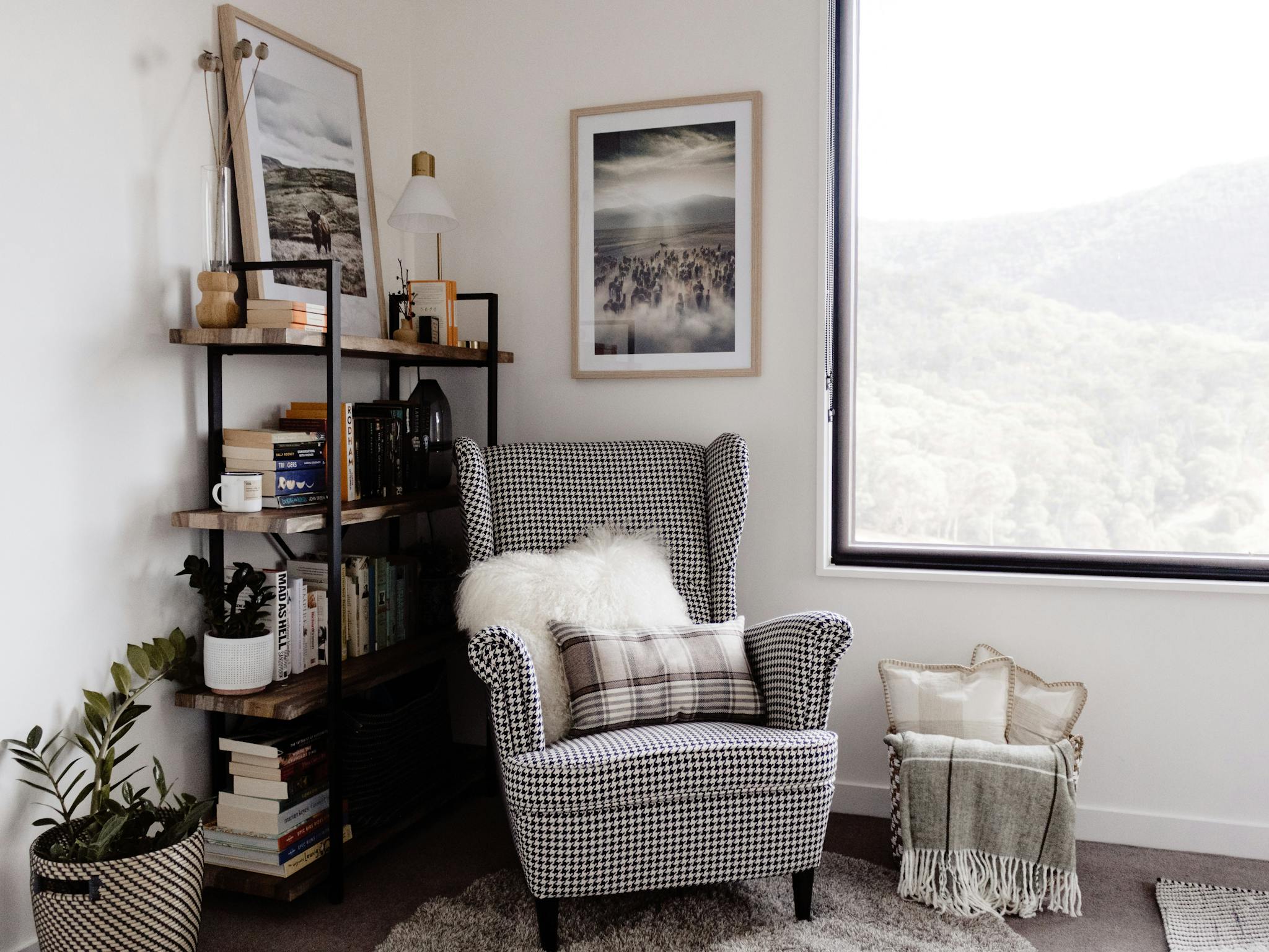 Roam Merrijig reading nook with wingback armchair, fluffy cushions and shelf full of books