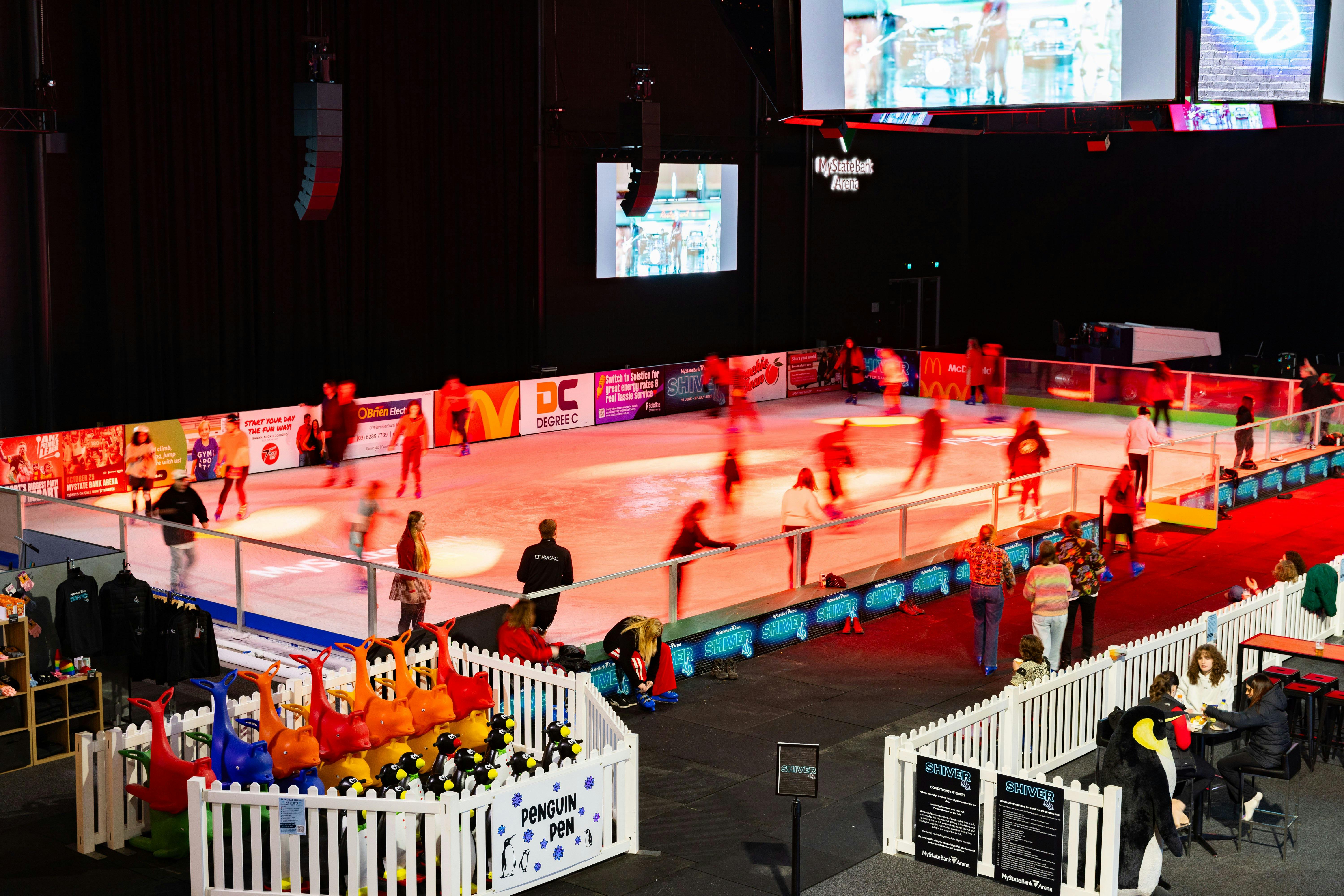 An ice rink in an arena with people skating