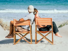 Couple relaxing in beach chairs overlooking the turquoise ocean near Salty Sands Retreats Port Neill