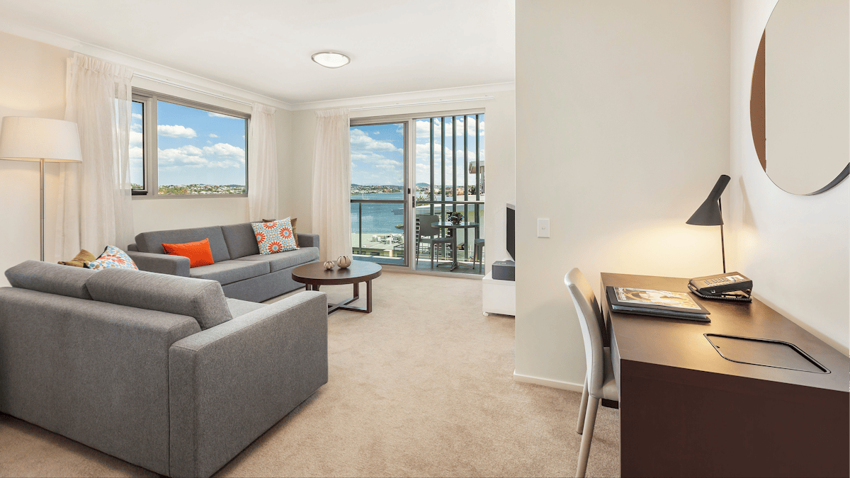 Living area with two, two seater couches, desk, private balcony