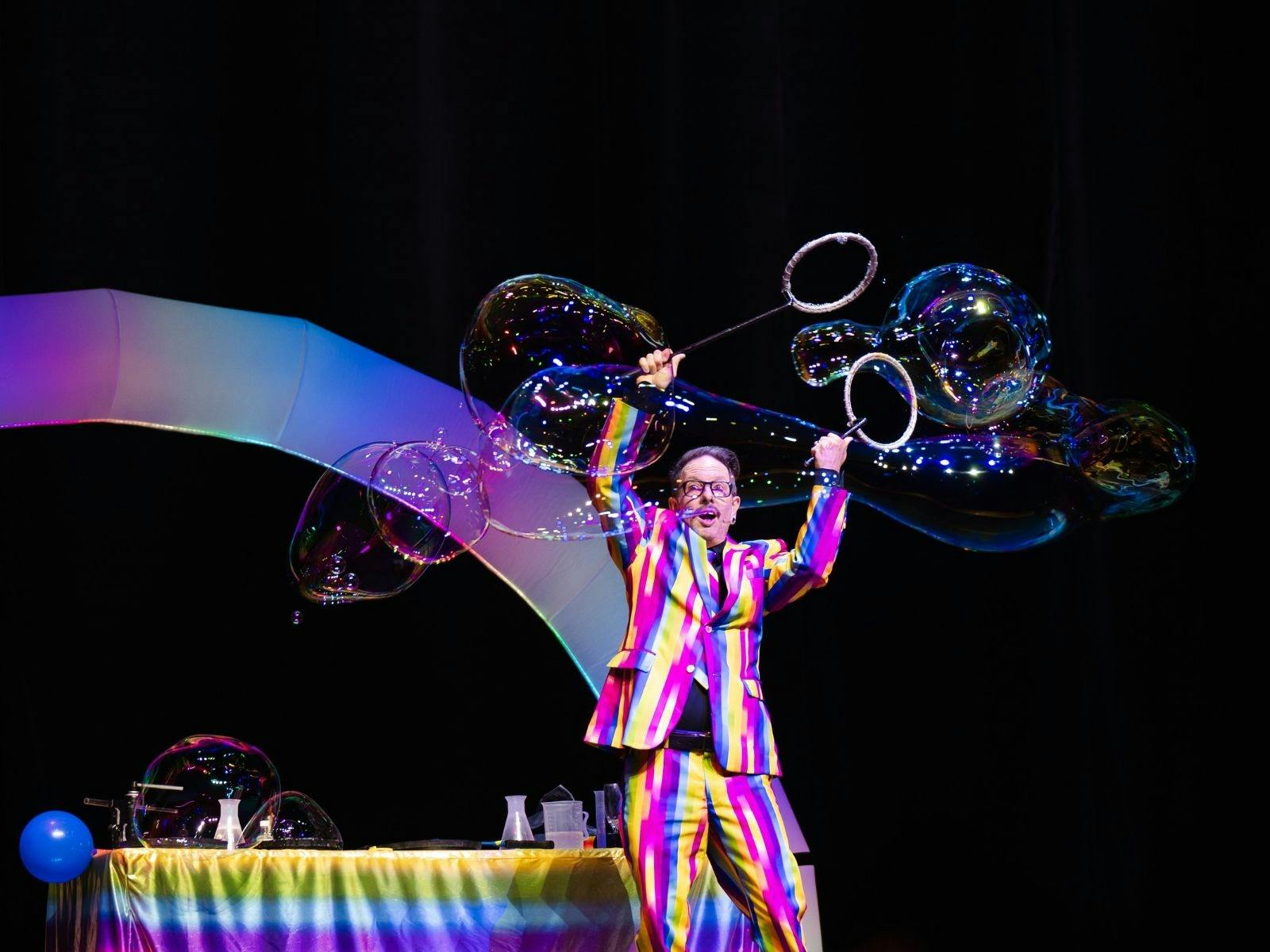 Man in multi coloured strip suit with large bubbles