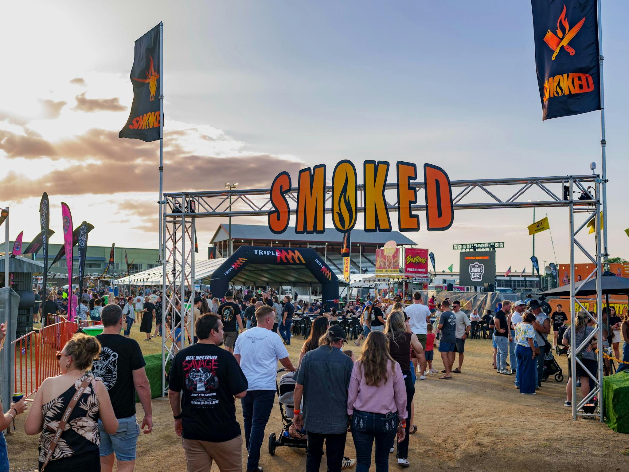 Smoked Festival sign with people walking underneath it Smoked Festival sign with people walking underneath it