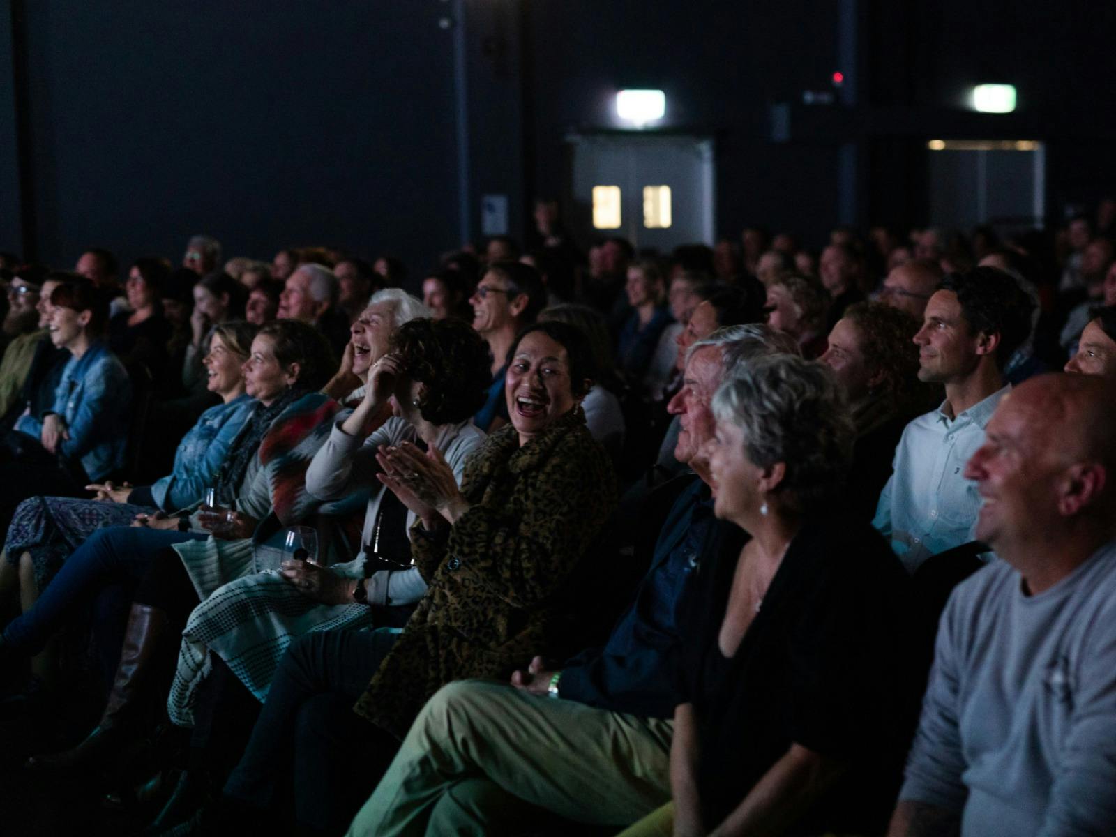 A crowd of people laughing and enjoying a show