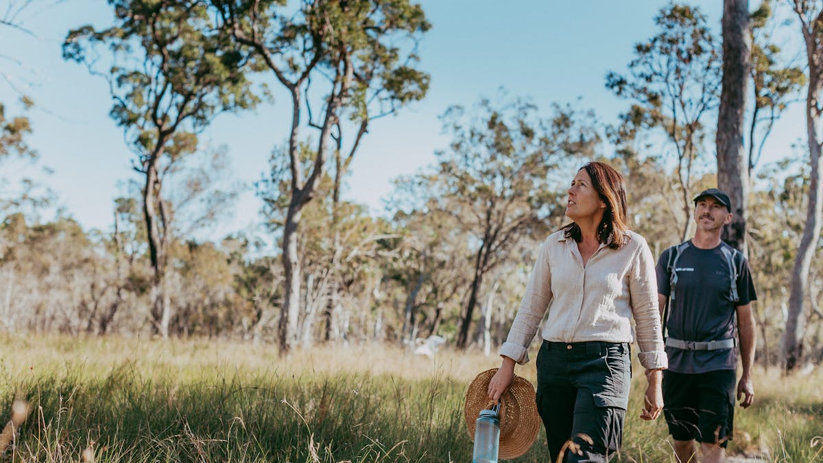 Woman and man walking through scenic bushland trails at Redlands Track Park, Redlands Coast, QLD