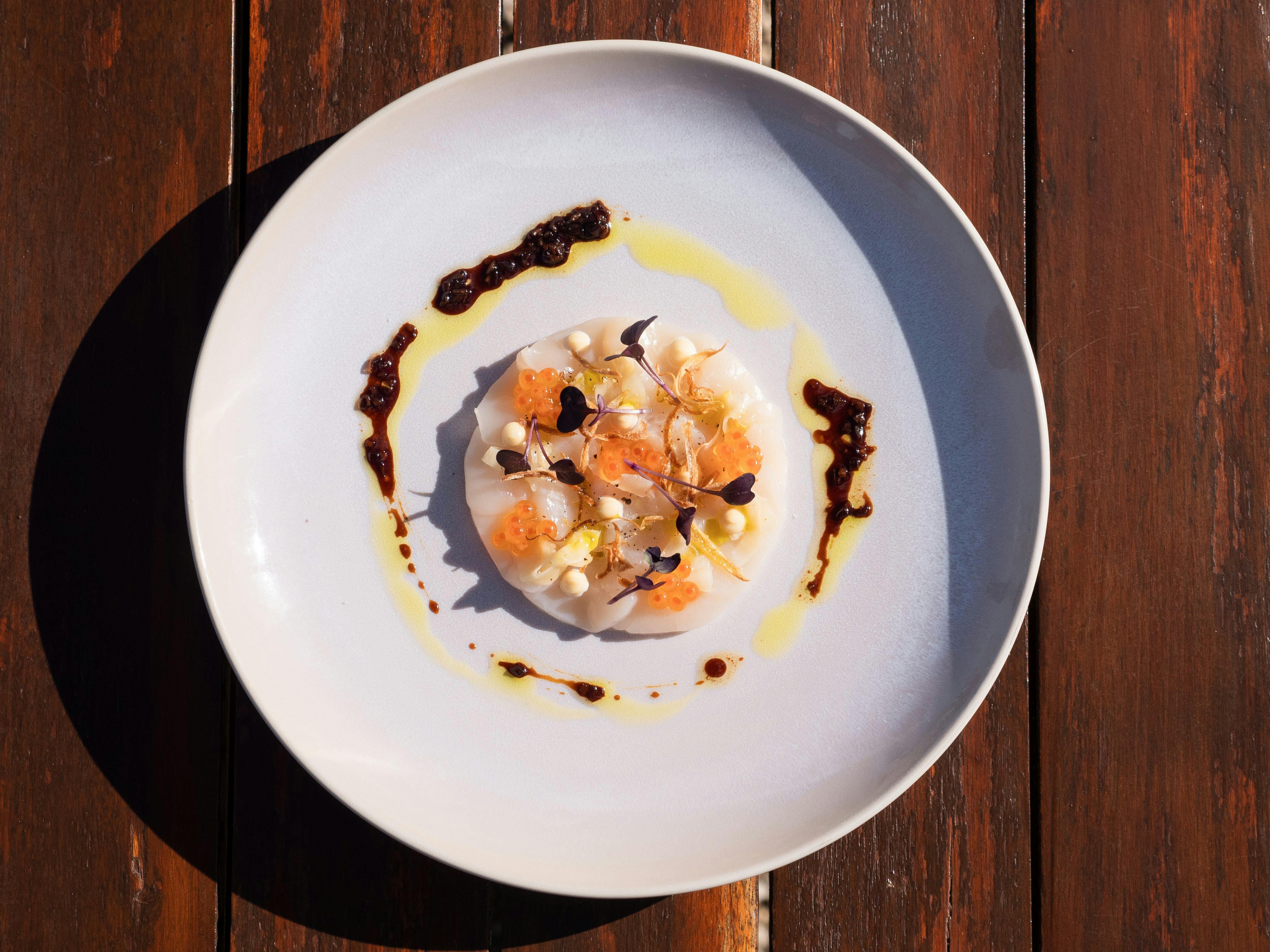 A bird’s eye view of a scallop sashimi dish from Swinging Bridge Indulge