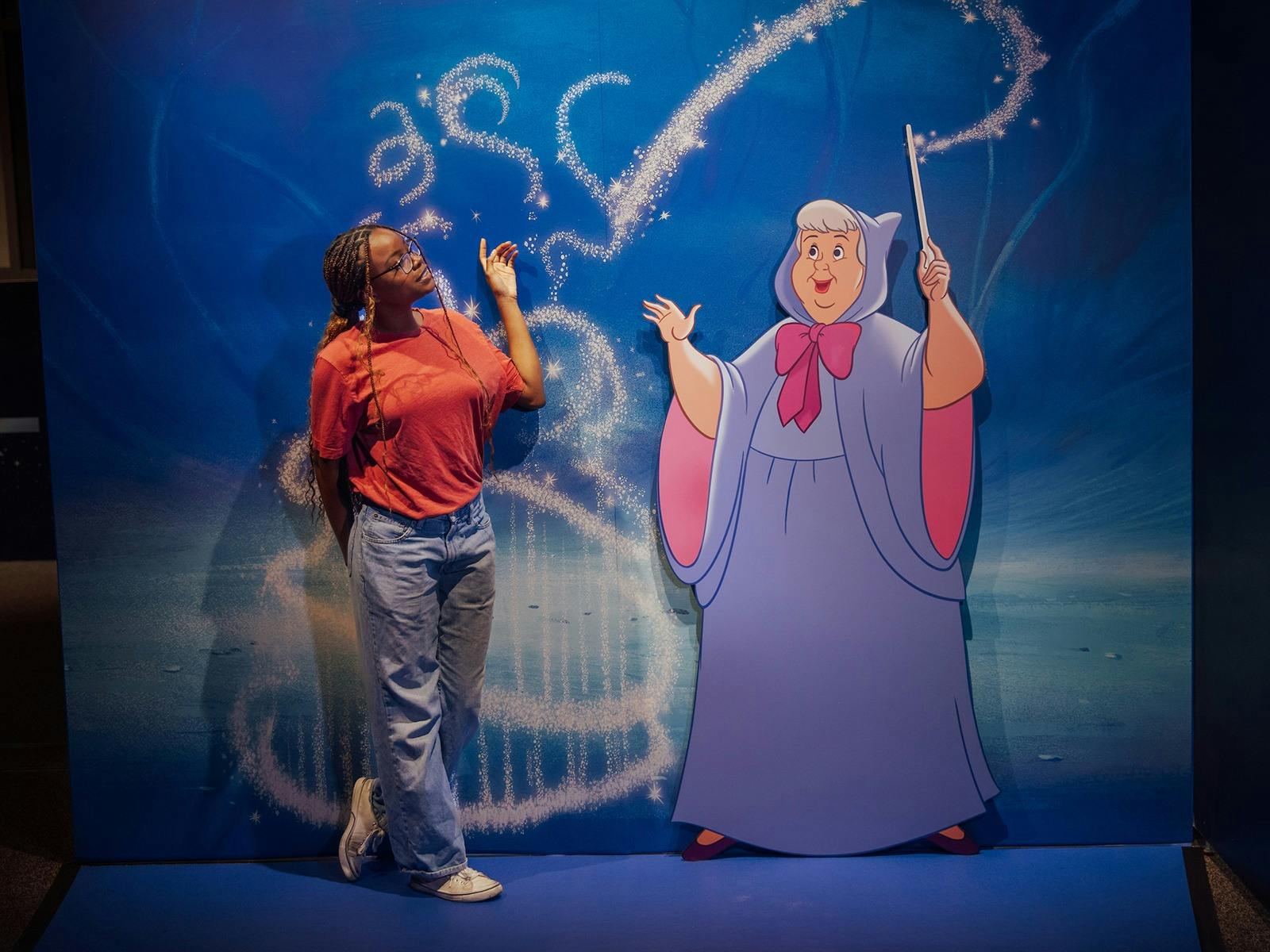Person standing next to animated character display Person standing next to animated character display