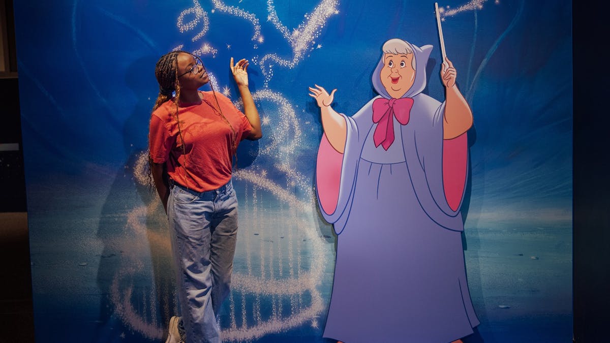Person standing next to animated character display