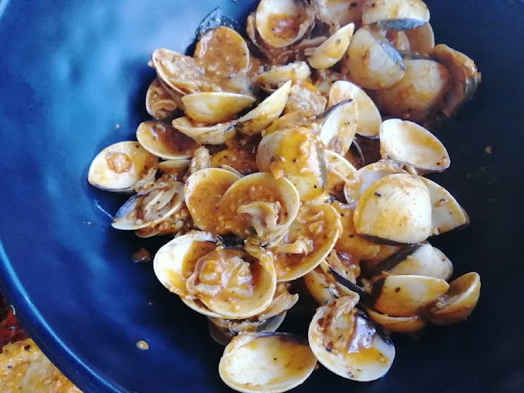 A dish full of cooked cajun clams