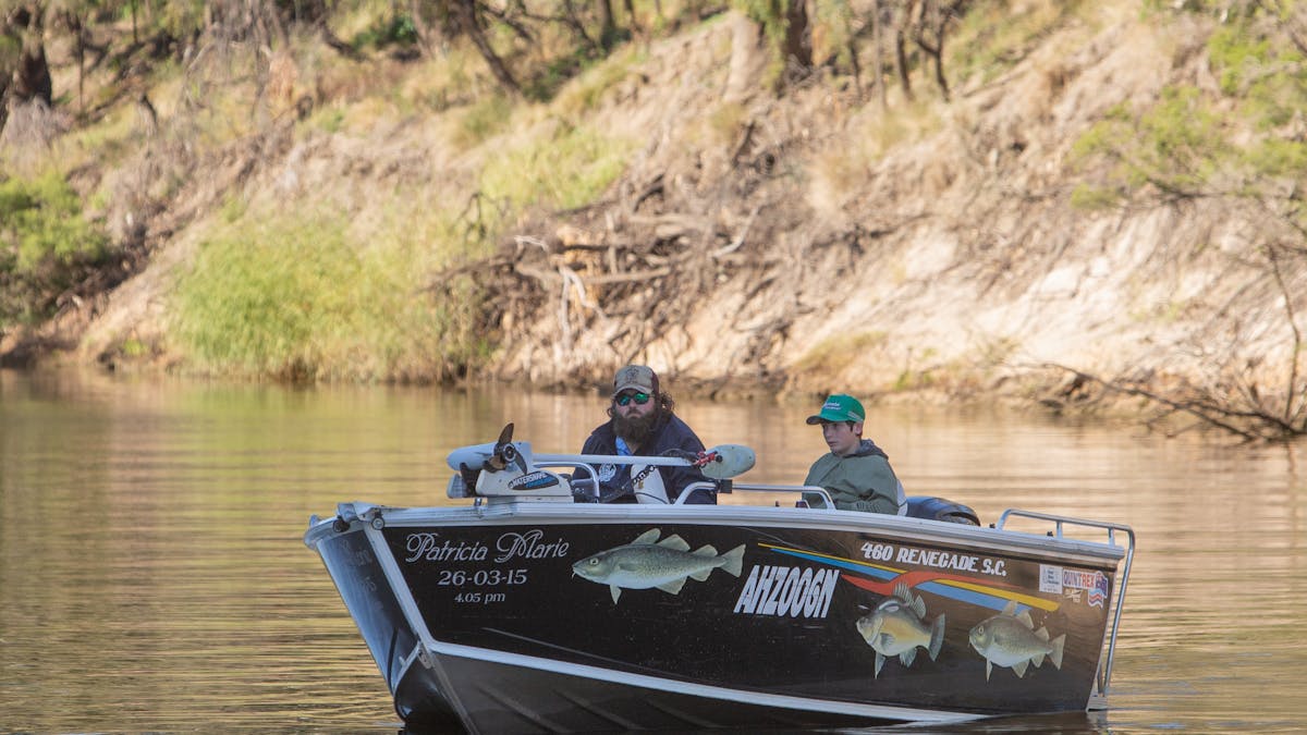 Two men sitting in a boat on the MacIntyre River