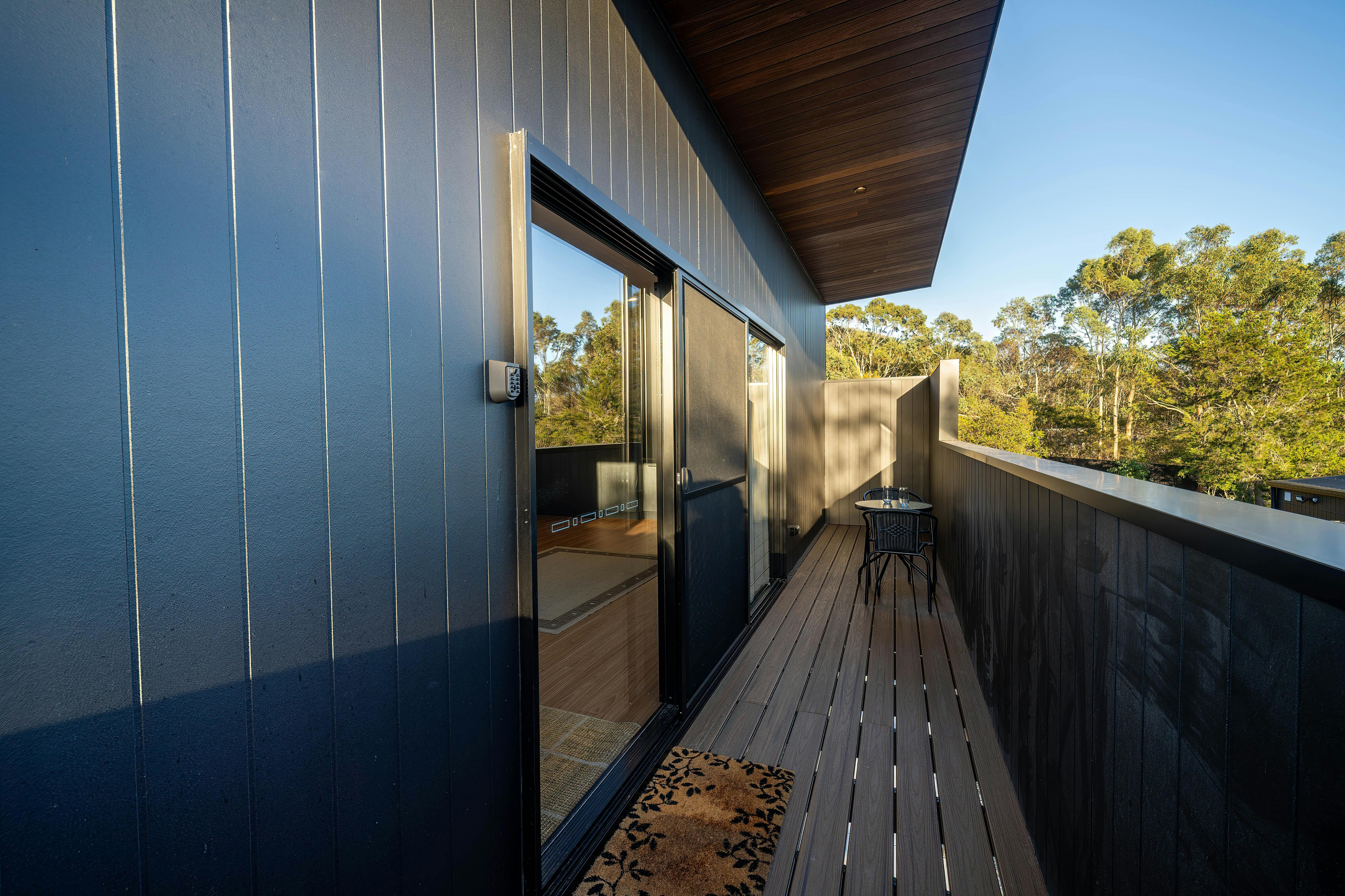 Deck area with balcony, entrance mat and table and chairs