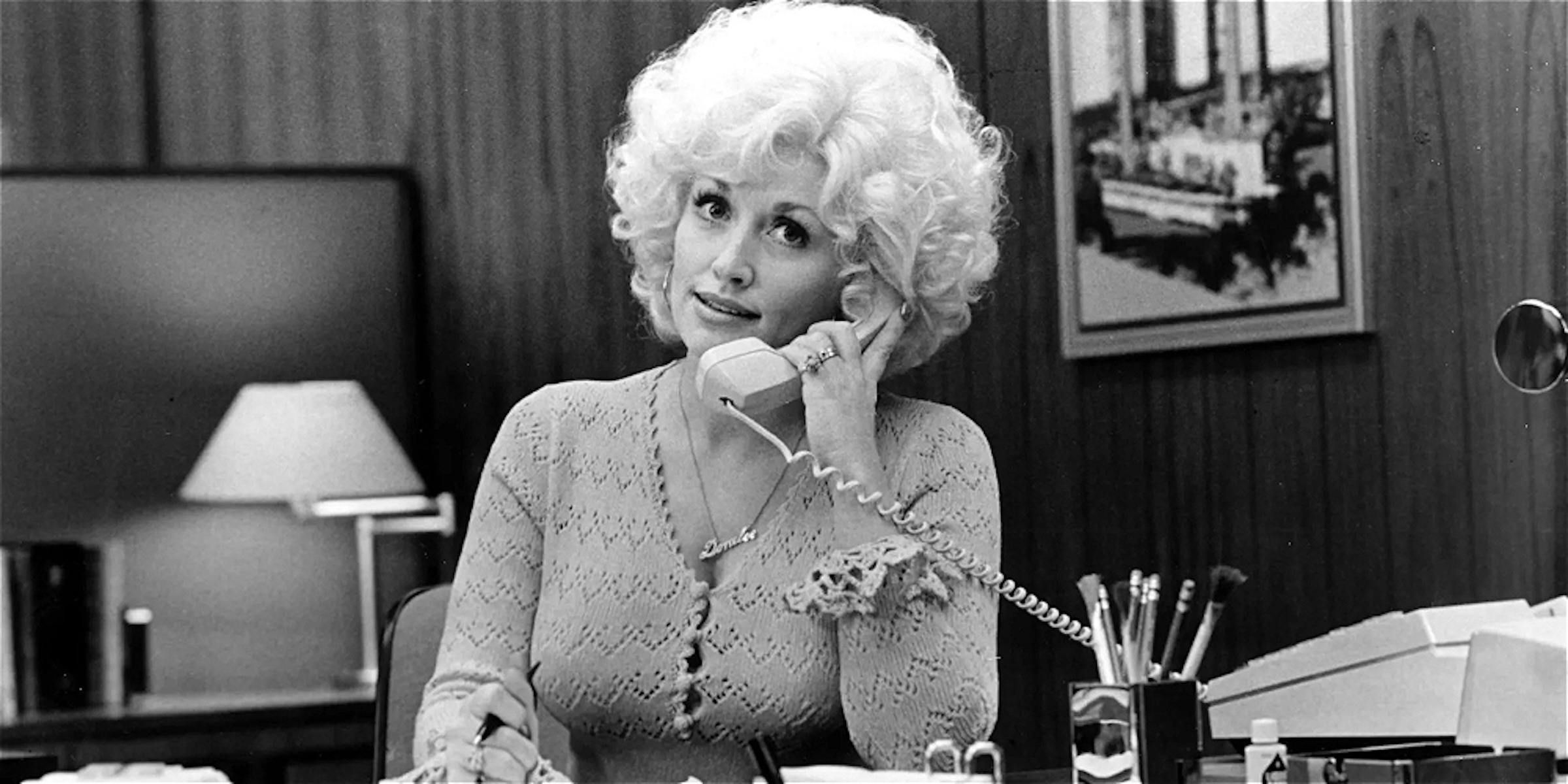 A women in black and white is on the phone.