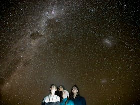 A family standing in front of the Milky Way