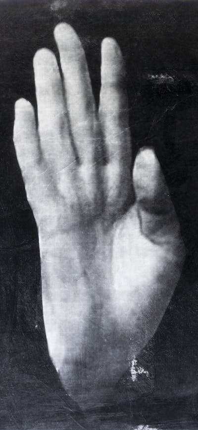 disembodied hand show the palm against a black background