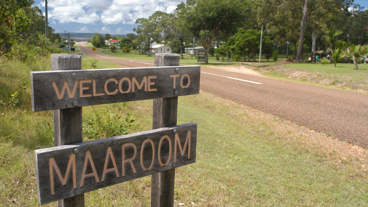 photo showing sign saying Welcome to Maaroom with hamlet in background
