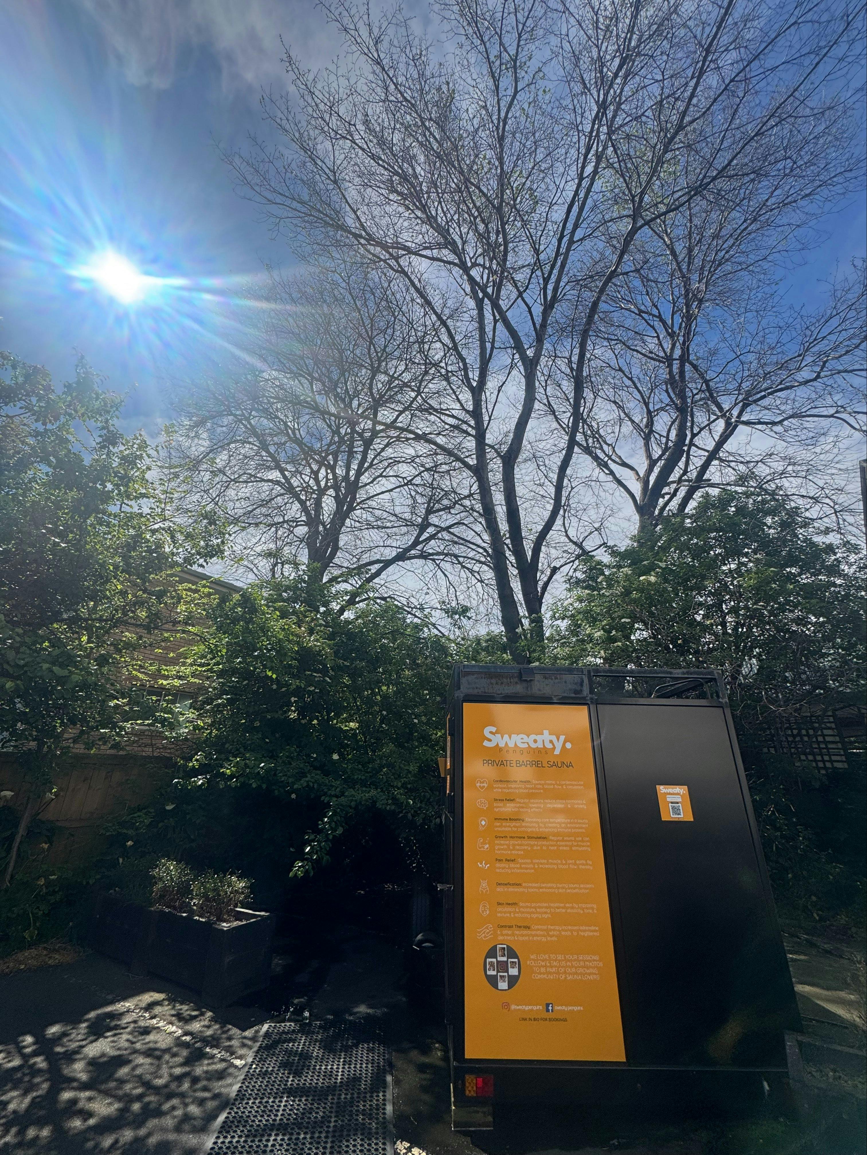 Exterior of the Sweaty Penguins sauna at Sandy Bay with the orange information panel.