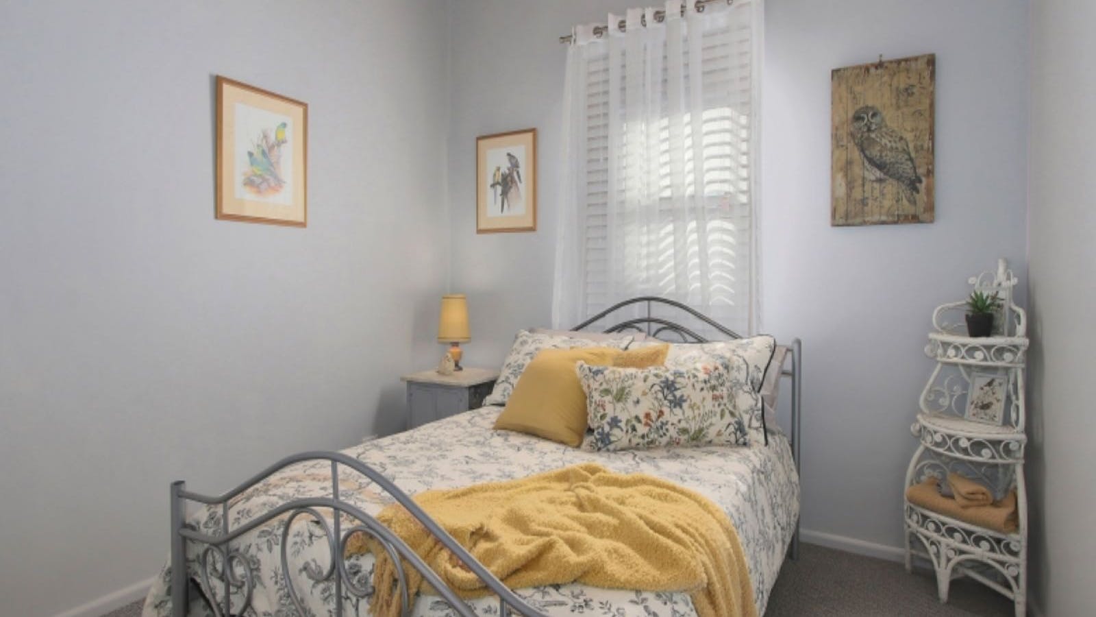 Bedroom, double bed in front of a window with white and yellow linin.