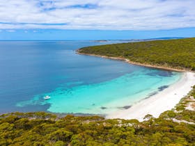 a white sand beach with clear blue waters in the memory cove wilderness protection area